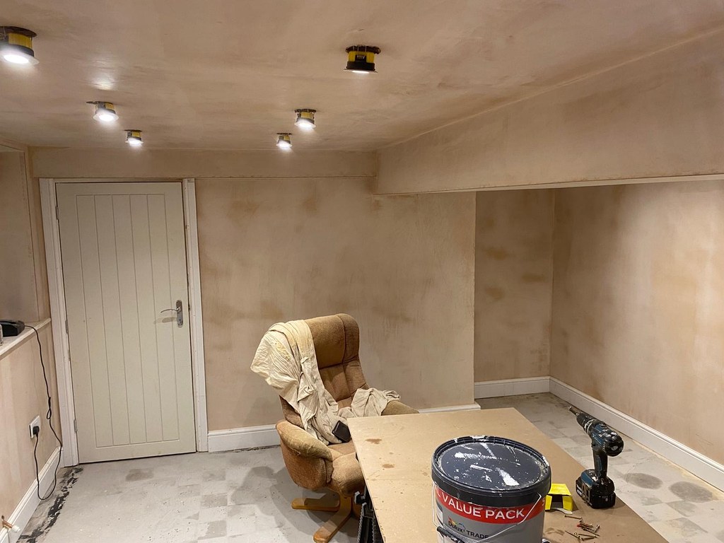Newly plastered garden room with bare pink walls and ceiling before painting