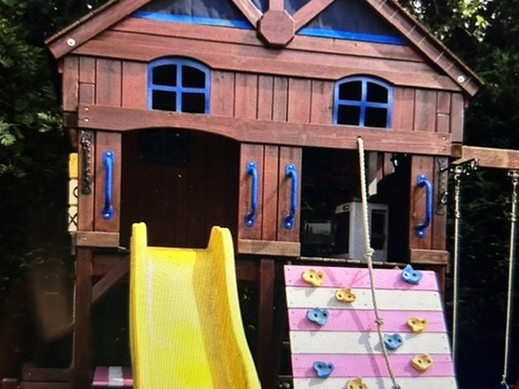 Timber garden playhouse with slide and climbing wall, painted and stained outdoors