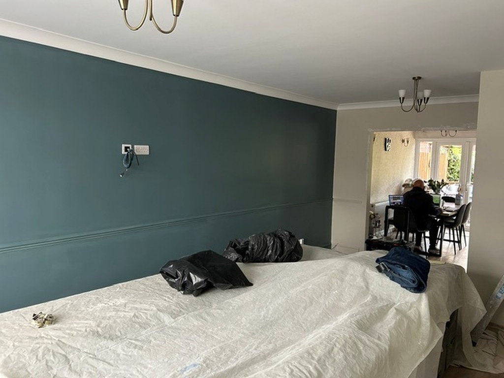 Dining room wall painted in deep teal with a white ceiling and coving