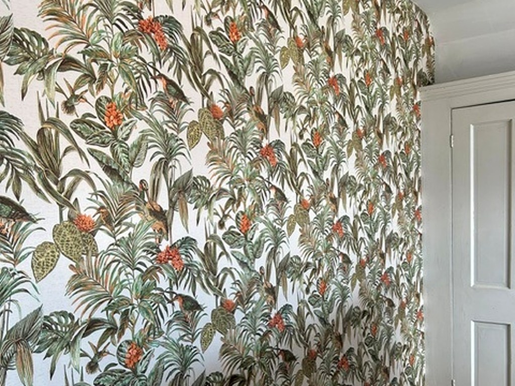 Green and orange botanical wallpaper hung on a landing wall beside a panelled door