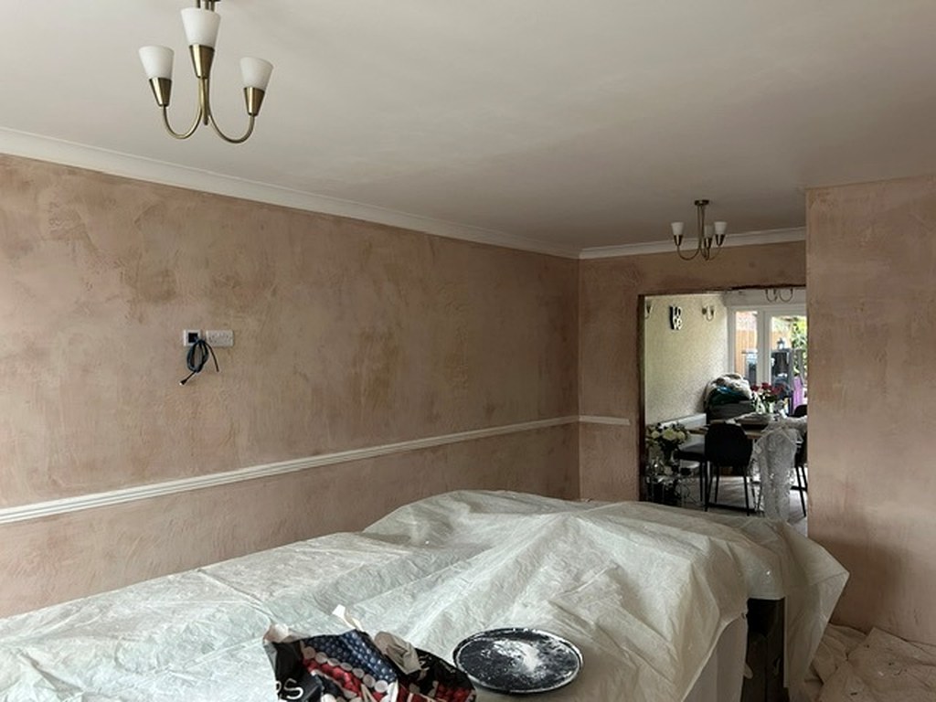 Dining room with patchy bare plaster walls and dado rail before painting